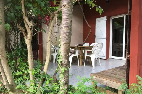 Terrasse ombragée du gîte Mimosa avec salon de jardin